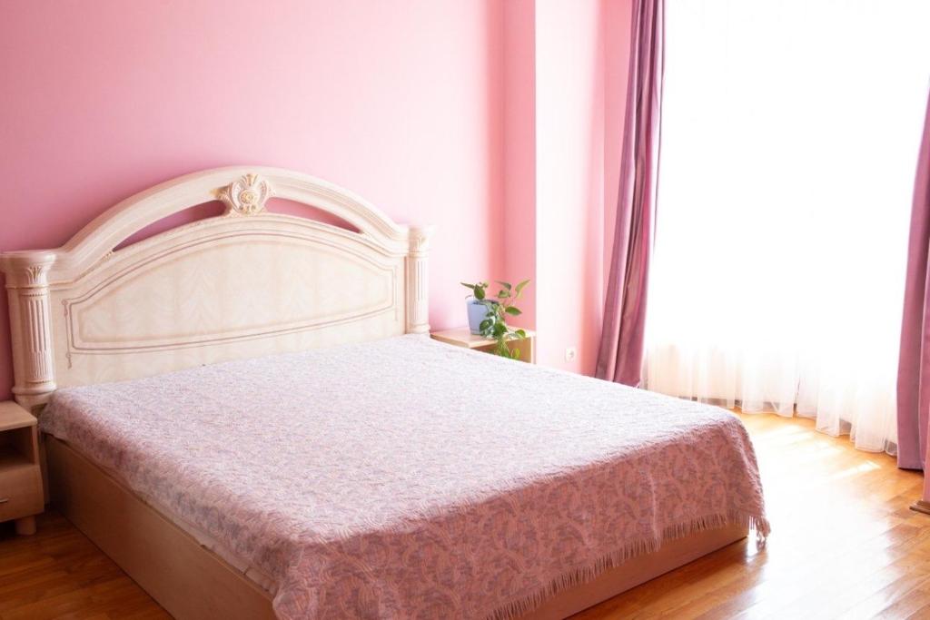 un letto bianco in una stanza con una grande finestra di Апартаменти на Сихові, Драгана 1й a Lviv