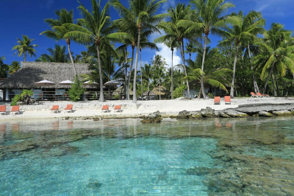 a view of a beach with palm trees and a resort at Raira Lagon in Avatoru