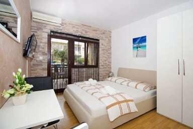 a bedroom with a large white bed and a window at Apartments Maky & Dino in Vodice
