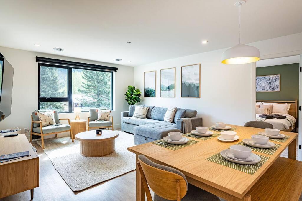 a living room with a table and a couch at Revy Bliss - Dazzling Condo in the Mountains in Revelstoke