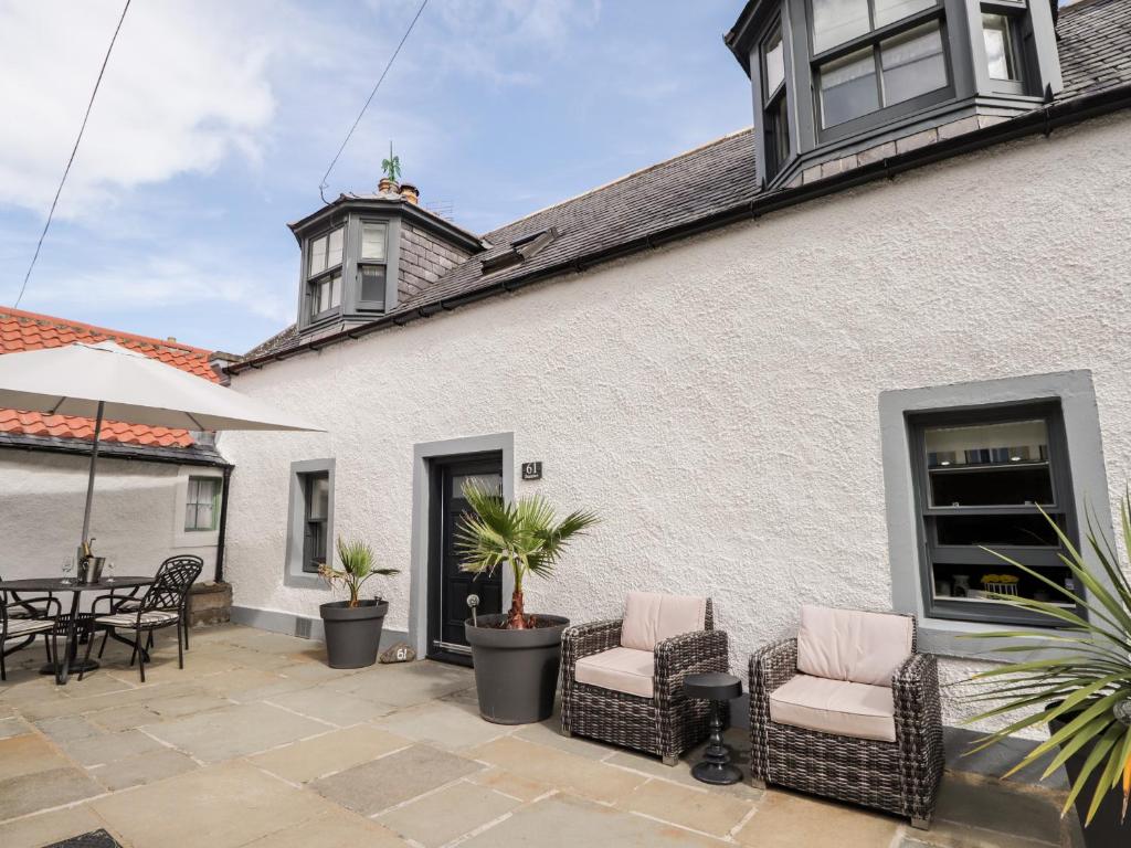 a patio with chairs and a table and a building at 61 Seatown in Buckie