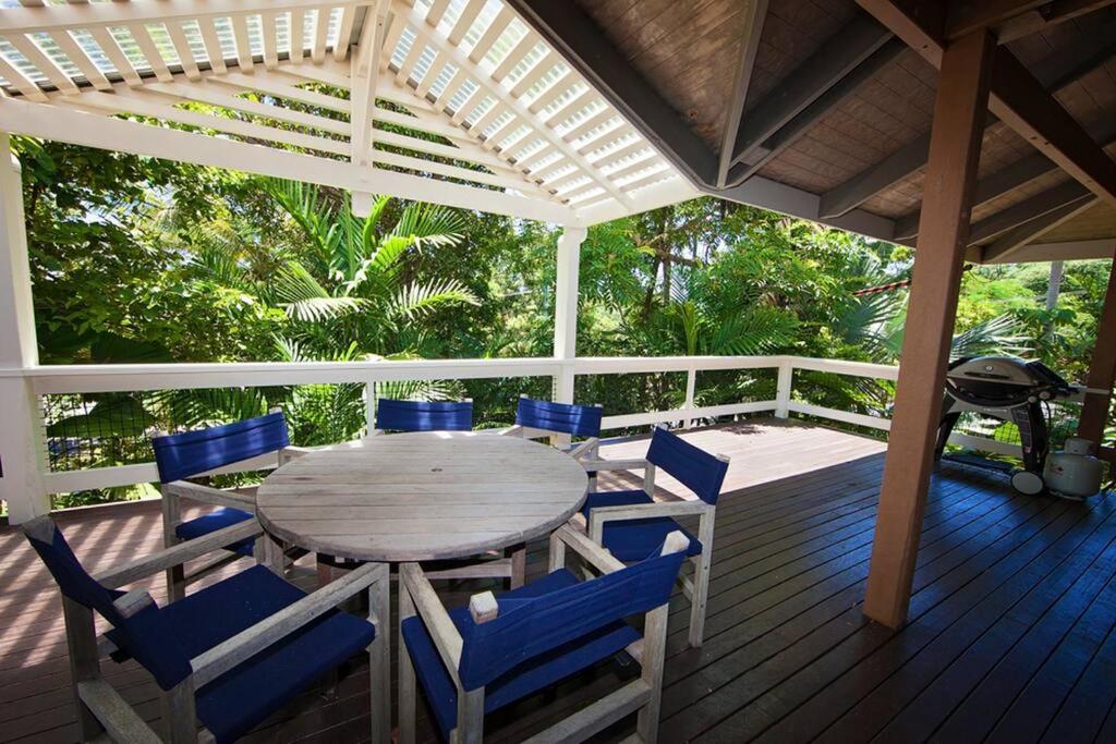 una mesa de madera y sillas en una terraza con parrilla en Breeya - A great tropical escape. Sleeps 9, en Mission Beach