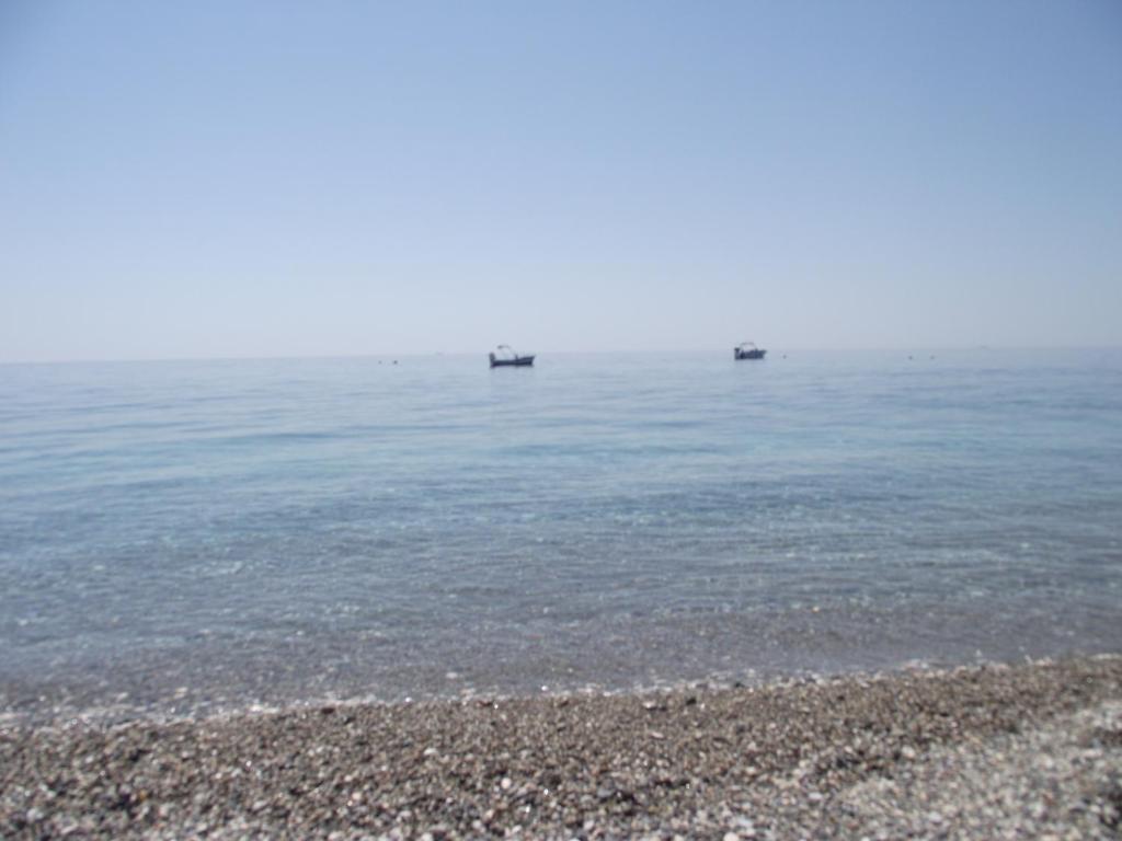 a beach with rocks and the water at B&B Il Mare degli Dei in Letojanni