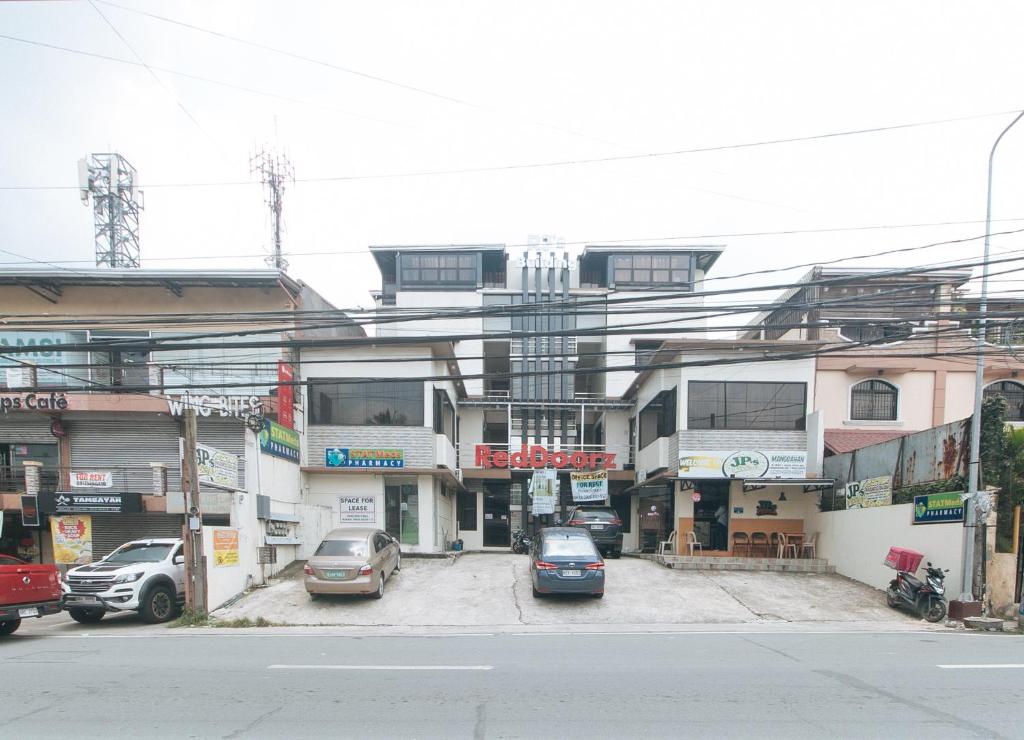 una calle de la ciudad con coches estacionados frente a los edificios en RedDoorz RJs Bldg near Lyceum Gen Trias Cavite en General Trias