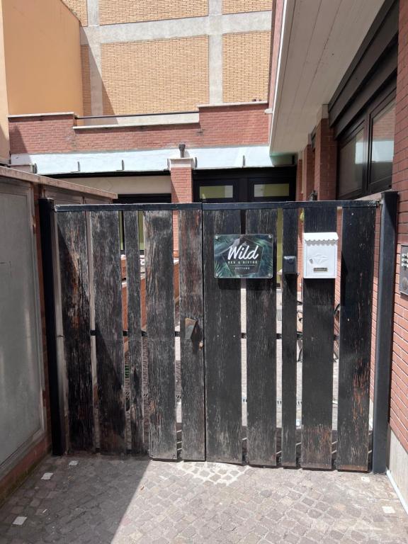 una entrada a un edificio con una puerta de madera en wild rooms&house en Nettuno