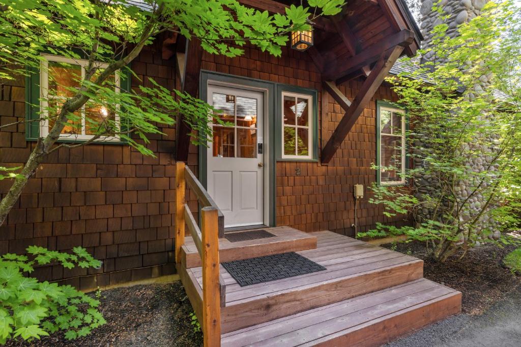 une petite maison avec un escalier en bois menant à une porte dans l'établissement Metolius Cabin 2, à Camp Sherman