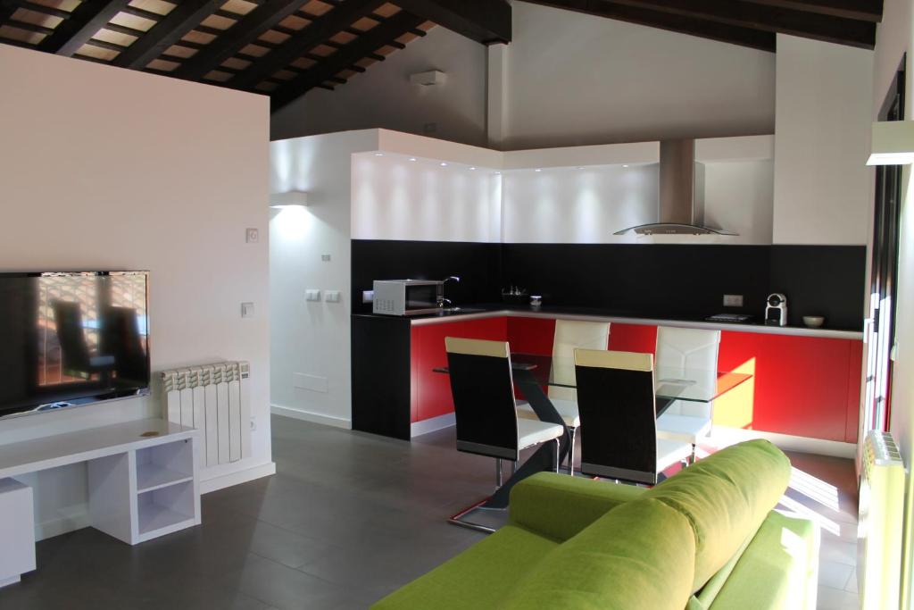 uma sala de estar com um sofá verde e uma cozinha em Apartment in the city of Olot Penthouse em Olot