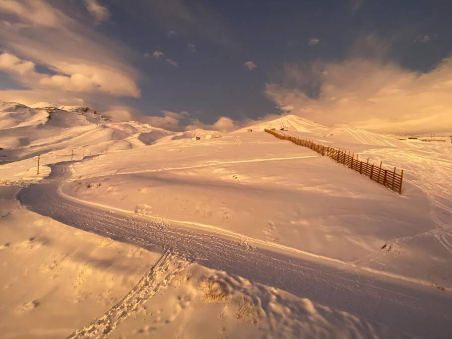 einen schneebedeckten Hügel mit einem Zaun darüber in der Unterkunft El Colorado, Farellones. in Santiago