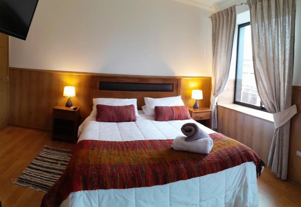 a hotel room with a teddy bear sitting on a bed at La Magia del Sur Valdivia in Valdivia