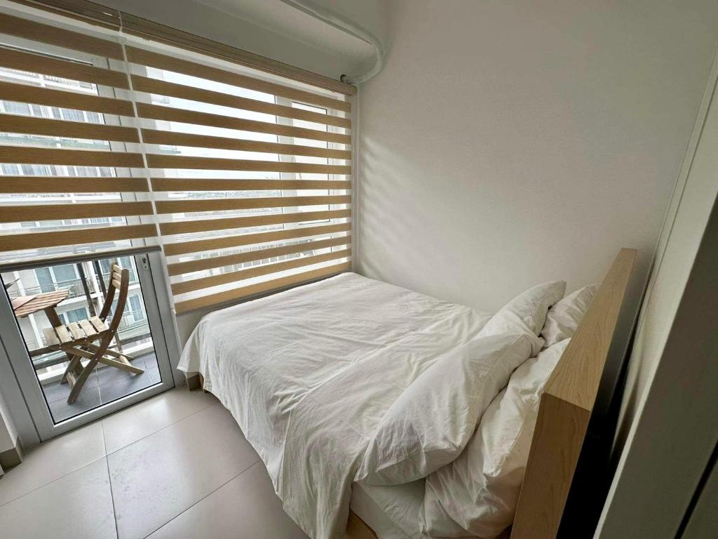- une petite chambre avec un lit et une fenêtre dans l'établissement Munting Tahanan sa Tagaytay, à Tagaytay