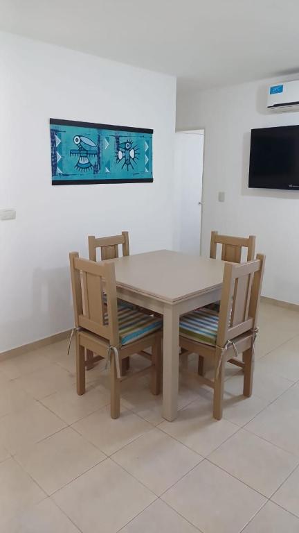a dining room table with two chairs and a television at tu lugar 2 in Córdoba
