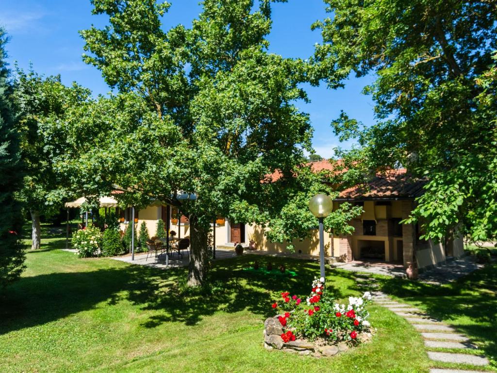 uma casa com um jardim com flores no quintal em Spacious Farmhouse in Castiglion Fiorentino with Garden em Castiglion Fiorentino