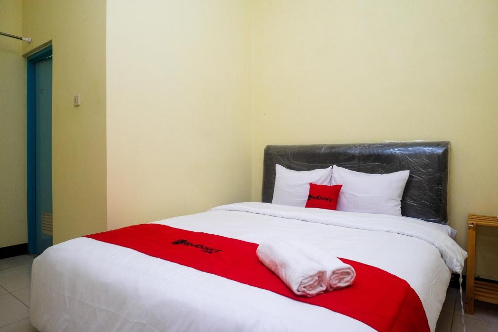 - une chambre avec un grand lit et 2 serviettes dans l'établissement RedDoorz near Tirtonadi Park Solo, à Kadiporo