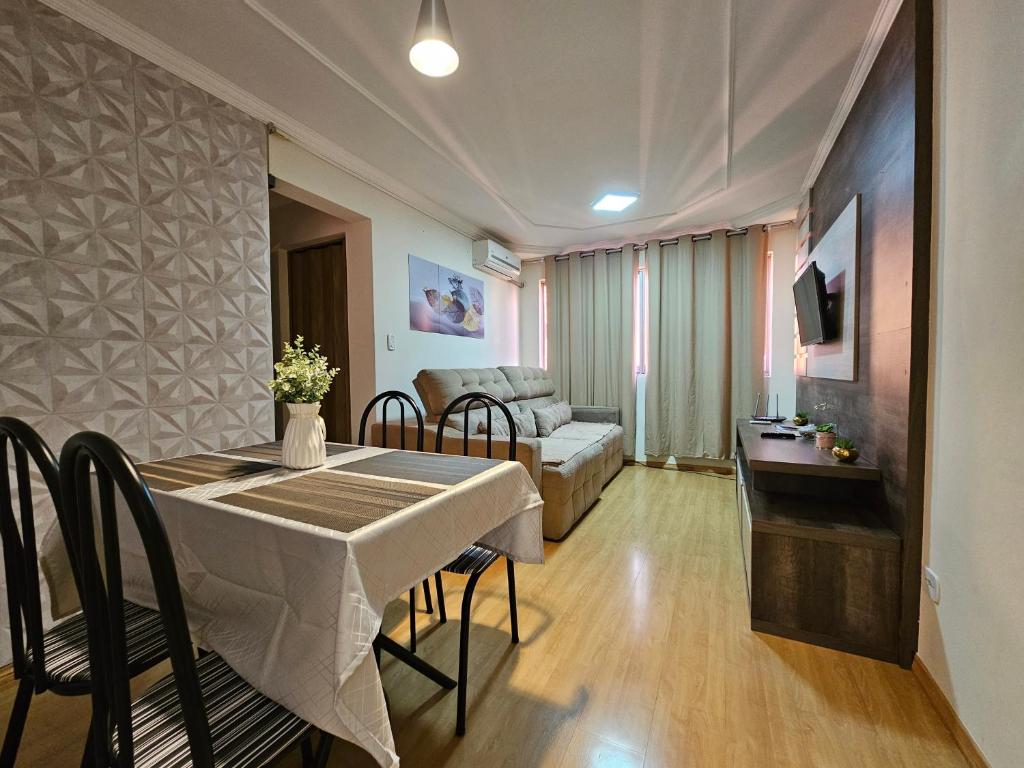 un soggiorno con tavolo da pranzo e divano di Conforto Urbano, Apartamento Acolhedor a Maringá