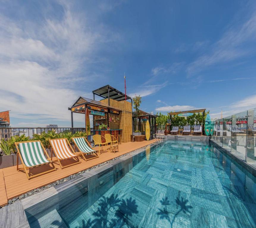 a swimming pool with lounge chairs on a building at Seahorse Signature Danang Hotel by Haviland in Danang