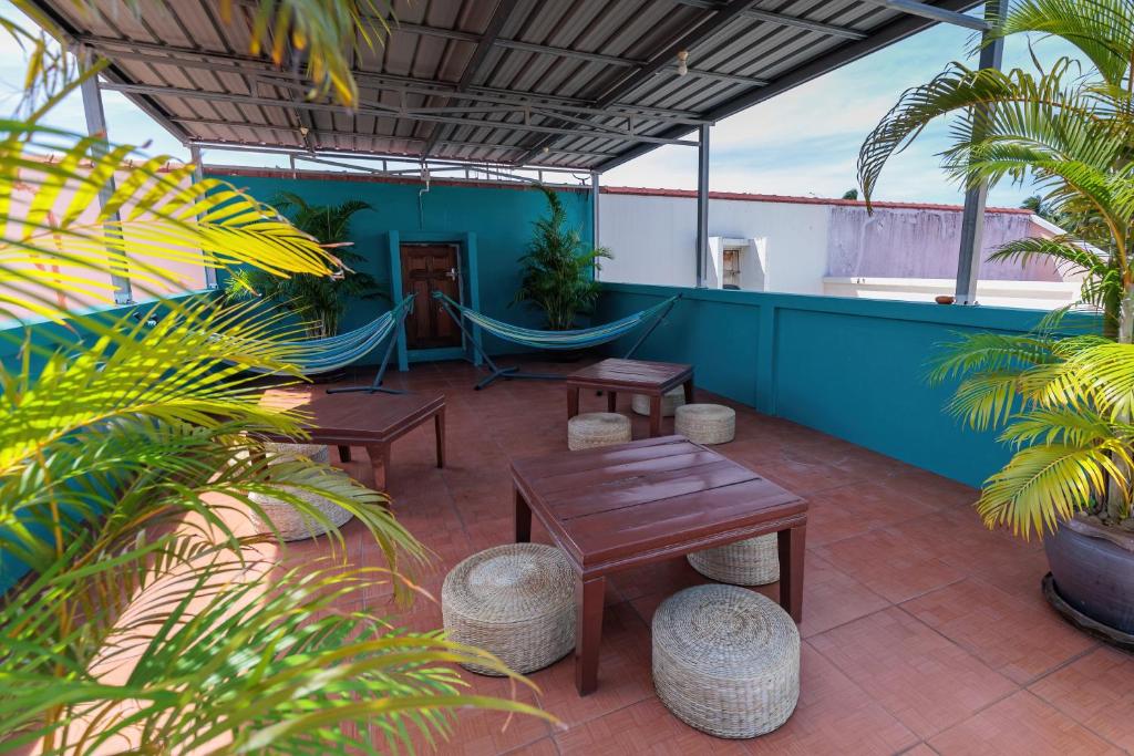 a patio with tables and hammocks on a roof at HOUSE OF HAPPINESS in Thongsala