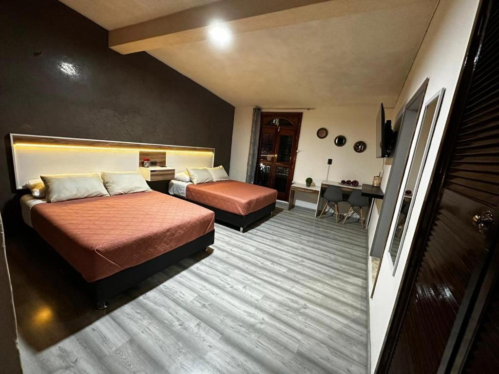 een hotelkamer met 2 bedden en een bureau bij Casa Marín in Oaxaca City