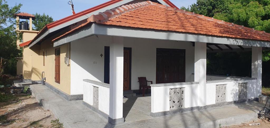 a small house with a red roof and a porch at La Felicita in Mannar