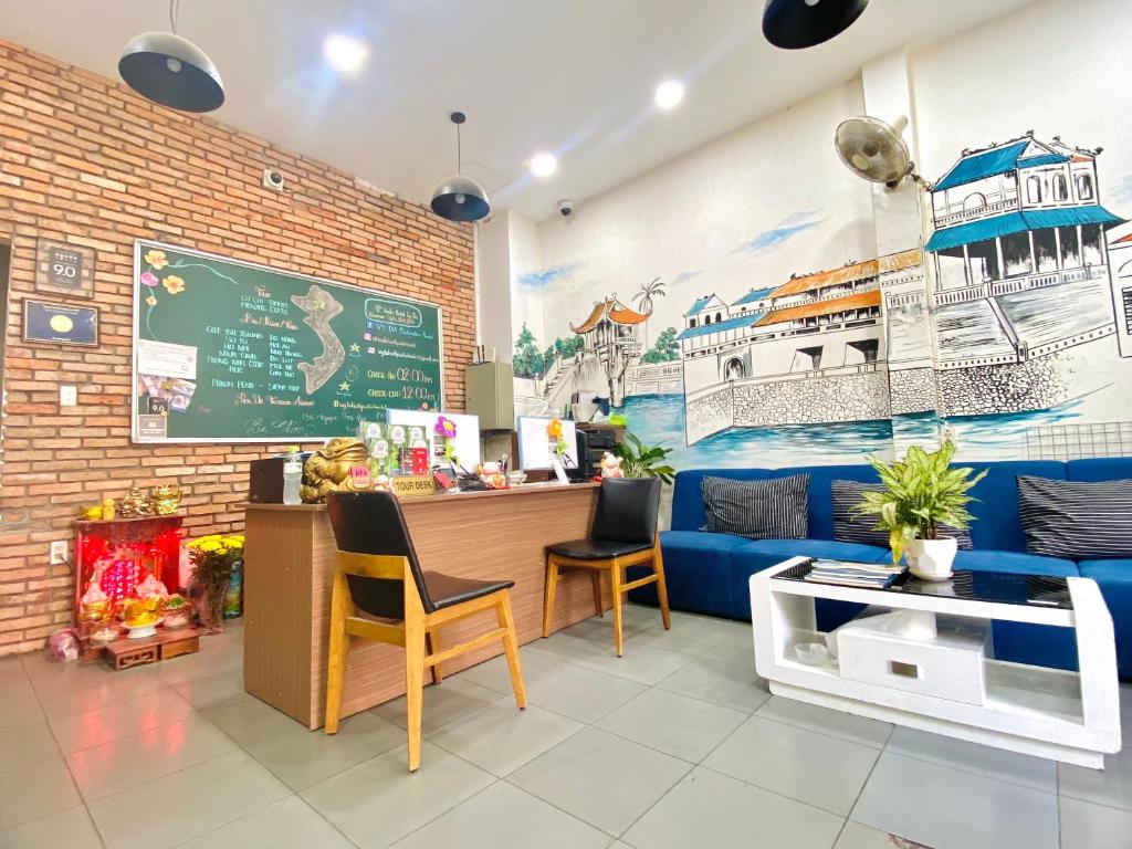 a coffee shop with a blue couch and a counter at Vy Da Backpacker Hostel in Ho Chi Minh City