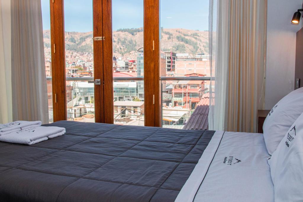 a bedroom with a large bed and a large window at Hotel Turístico Everest in Huaraz