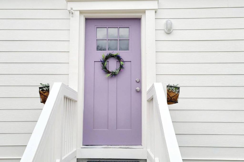 eine lila Tür an einem weißen Haus in der Unterkunft 10 Mins Downtown 20 Mins Airport PET FRIENDLY in Decatur
