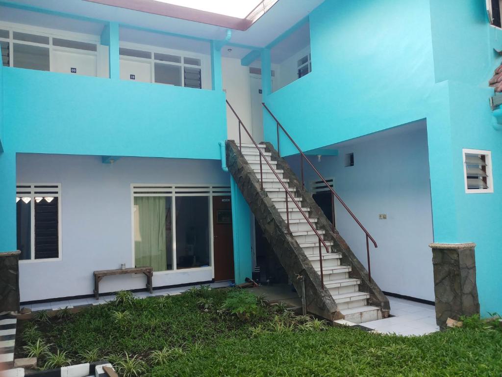 ein blaues Gebäude mit einer Treppe davor in der Unterkunft Welirang 20B Homestay - Max 2 Orang Per Kamar in Malang