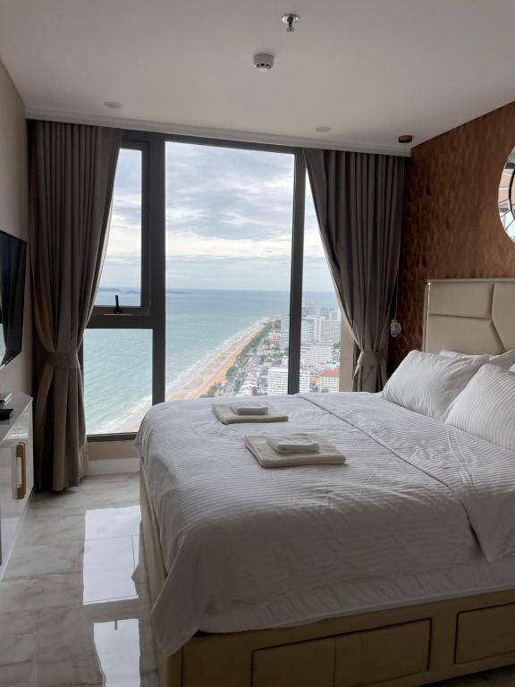 Schlafzimmer mit einem großen Bett und Meerblick in der Unterkunft Copacabana jomtien beach high floor in Jomtien Beach
