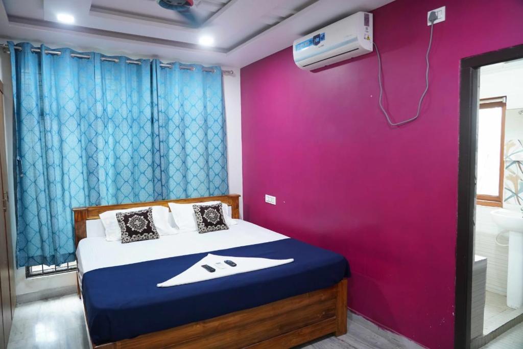 a bedroom with a bed with a purple wall at Sea side guest house vizag in Visakhapatnam