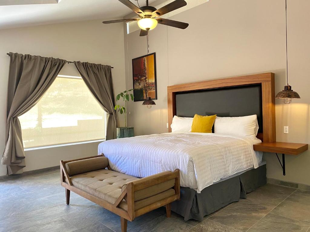 - une chambre avec un grand lit et un ventilateur de plafond dans l'établissement Tierra Mia Hacienda Ruta del Vino, à Valle de Guadalupe