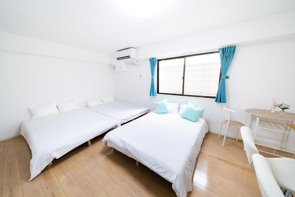 twee bedden in een kamer met een raam bij SUA HOTEL Nishikasai in Tokyo