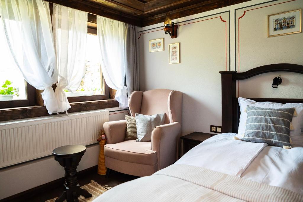 a bedroom with a bed and a chair and a window at Къща ЕТНО in Koprivshtitsa