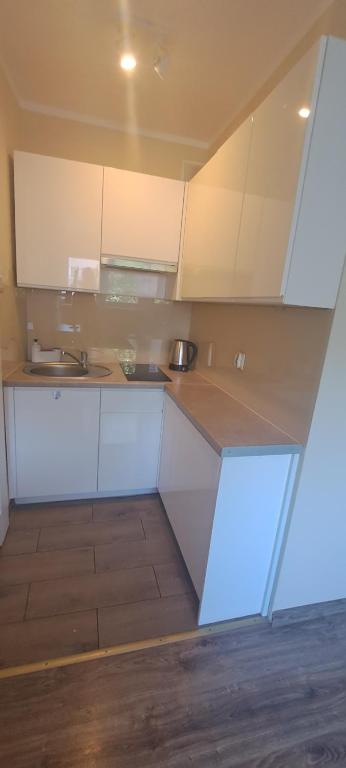 a kitchen with white cabinets and a sink at Apartament Barcelona in Kłodzko