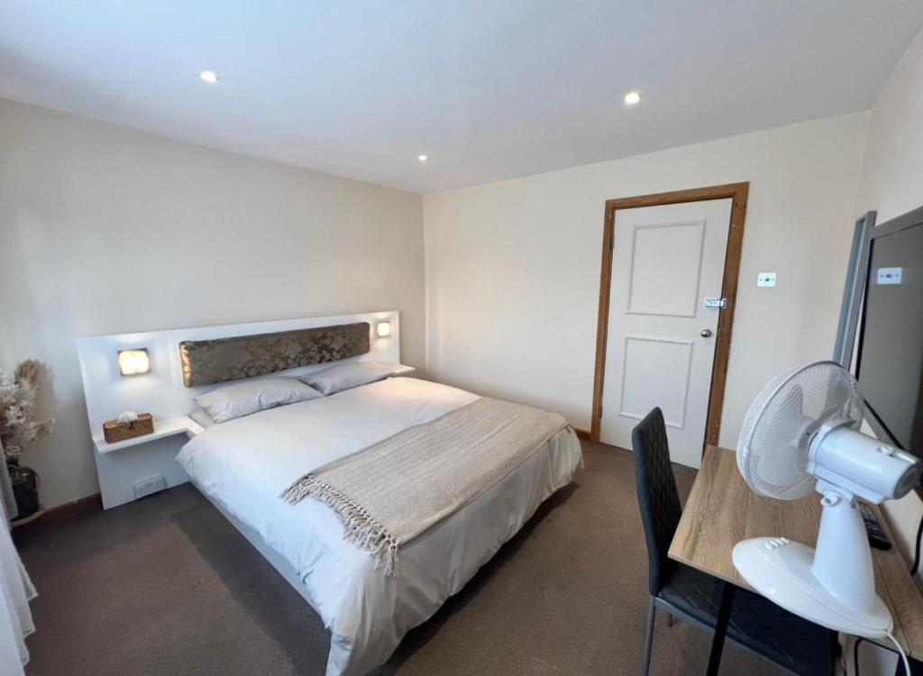 a bedroom with a bed and a desk with a camera at Comfy Room for ONE person - Netflix, Amazon Prime & Disney Plus in Bromley