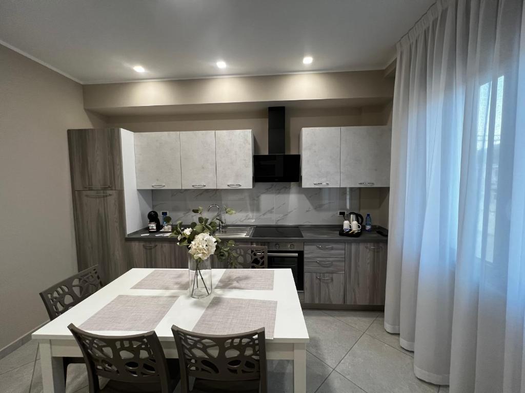 a kitchen with a table with a vase of flowers on it at B&B Lamezia Central Airport in SantʼEufemia Lamezia