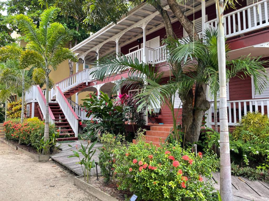 ein Haus mit Treppen und Blumen davor in der Unterkunft Alux House in Placencia Village