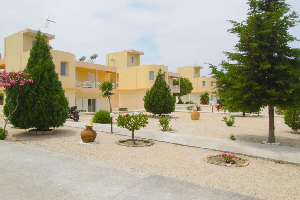 a building with trees and plants in a courtyard at Treditto House - Ground Floor residence C1 in Koskinou