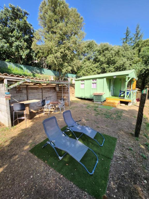 zwei Gartenstühle auf dem Rasen vor einem Haus in der Unterkunft Chalet in Petreto-Bicchisano