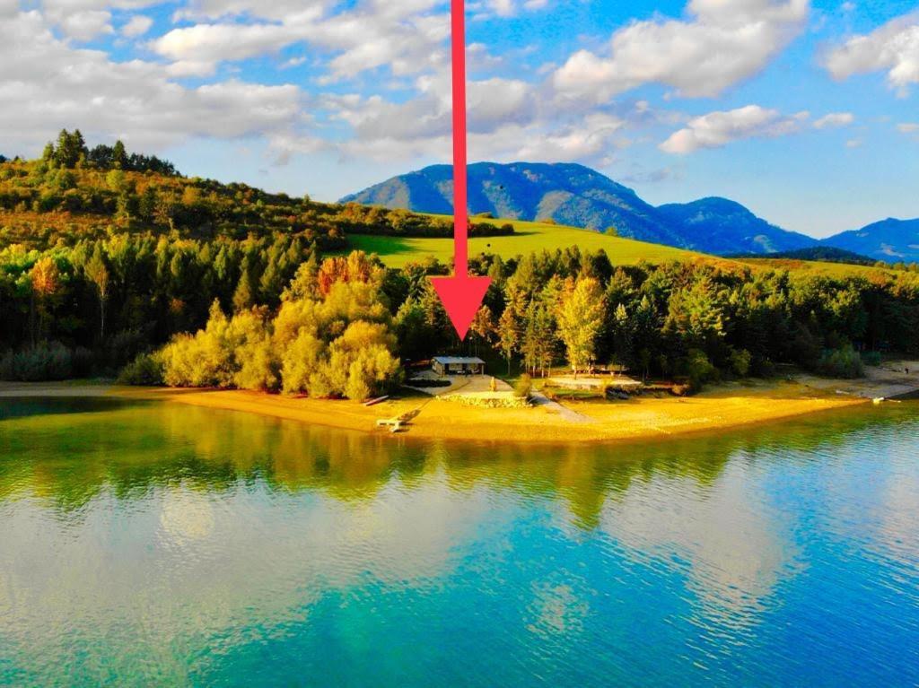 an island in the middle of a lake with a red arrow at Mobilný domček na brehu Liptovskej Mary 