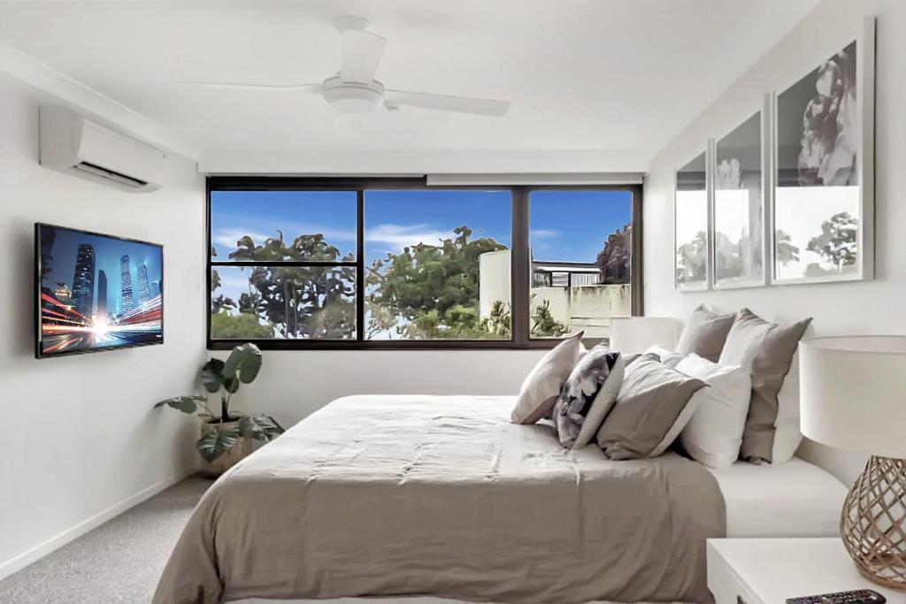 a bedroom with a large bed with a large window at Aquarius Luxury Apartment in Cairns