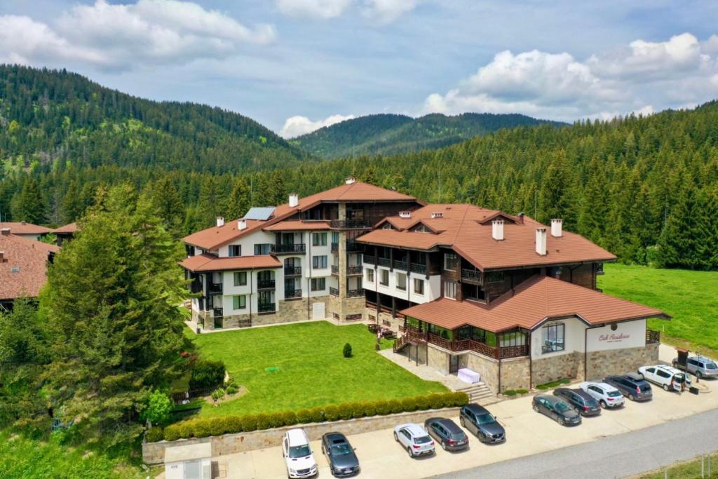 an aerial view of a large house with cars parked in a parking lot at Oak Residence Hotel & Relax in Smolyan