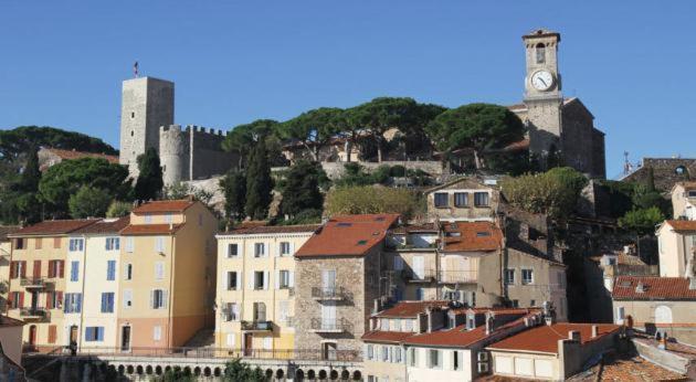 a group of buildings with a clock tower on a hill at Appartement Foussard in Cannes
