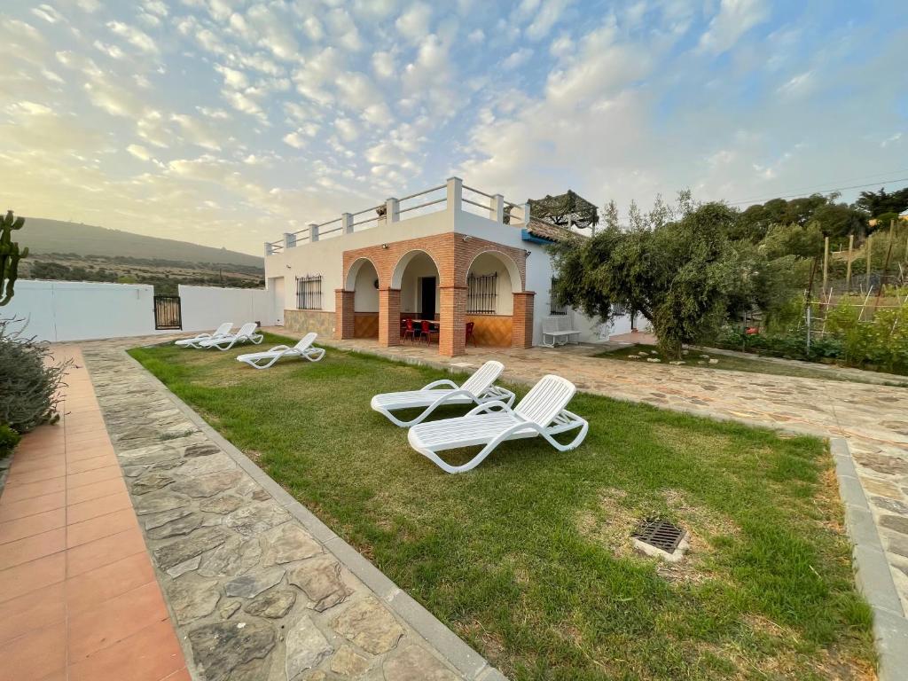 a group of lawn chairs sitting on the grass in front of a house at Chalet en la playa de Bolonia in Tarifa