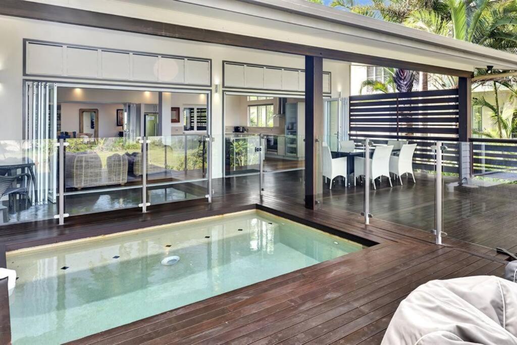 a house with a swimming pool on a wooden deck at Ripples on the Beach - Beachfront Mission Beach in Mission Beach