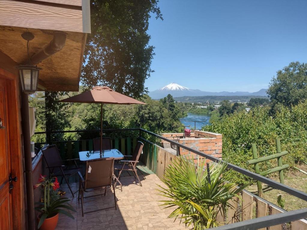 a patio with an umbrella and a table and chairs at Cabañas Vistas al Río Villarrica in Villarrica