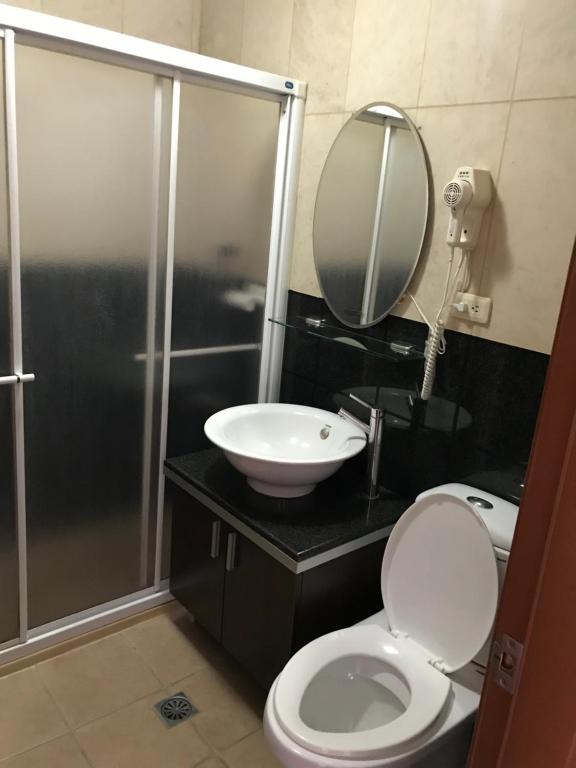 a bathroom with a sink and a toilet and a mirror at Love in Hualien B&amp;B in Hualien City