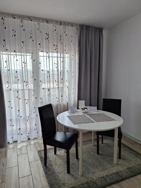 ein Esszimmer mit einem weißen Tisch und 2 Stühlen in der Unterkunft FARMEC Apartament in Cluj-Napoca