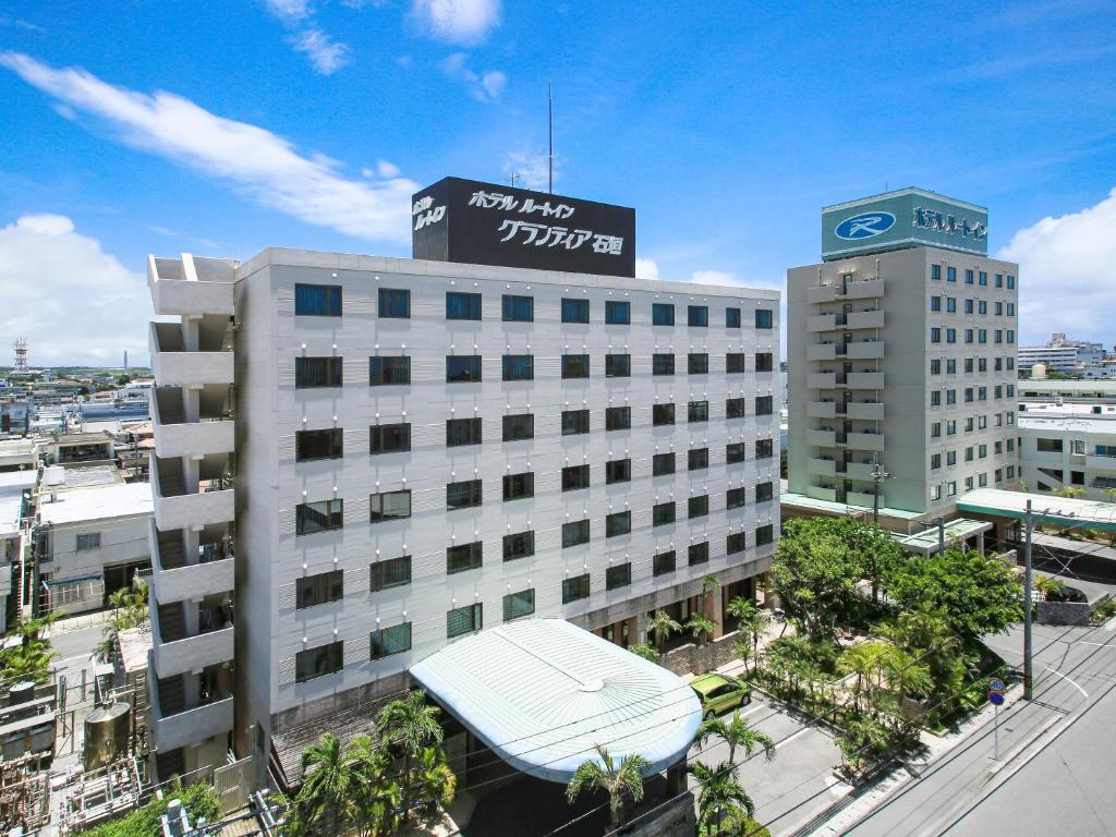 a large white building with a sign on top of it at Route Inn Grantia Ishigaki in Ishigaki Island