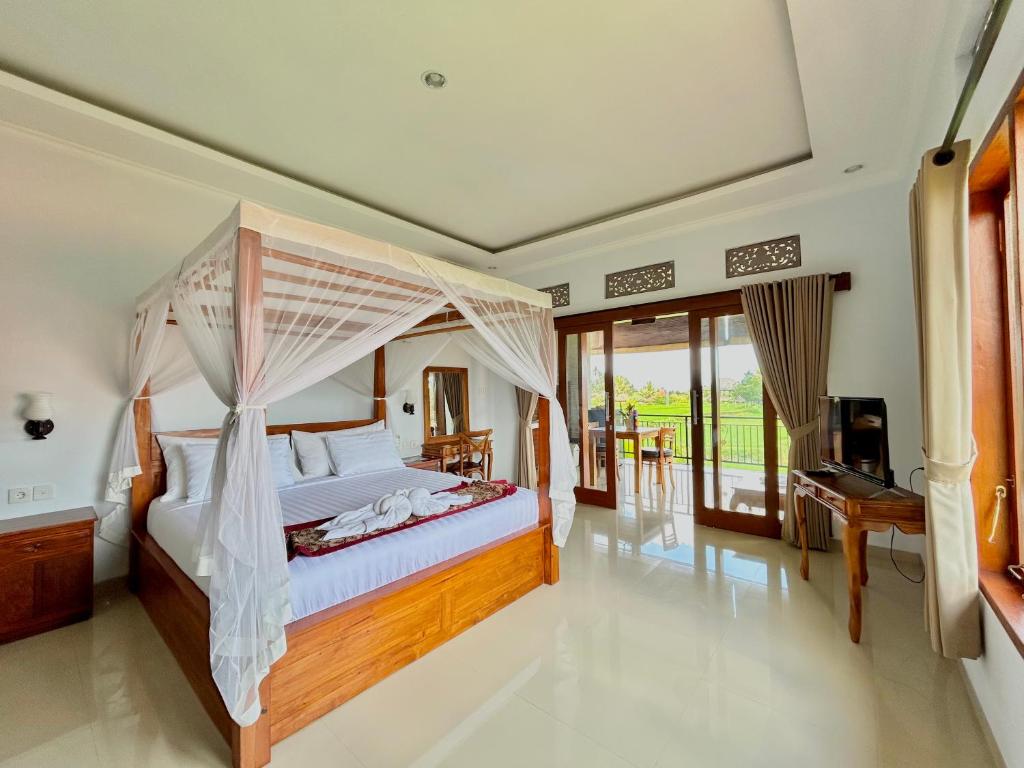 a bedroom with a bed with a canopy at Bhakti Ubud Villa in Ubud