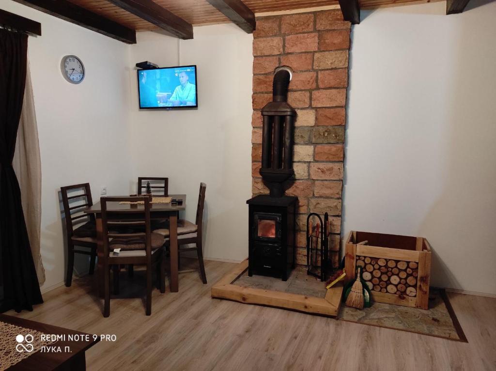 a living room with a wood stove and a table at Planinska kuca Gora in Mitrovac