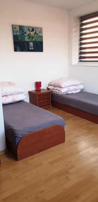 2 Einzelbetten in einem Zimmer mit Fenster in der Unterkunft R-PUNKT POKOJE GOŚCINNE in Płock
